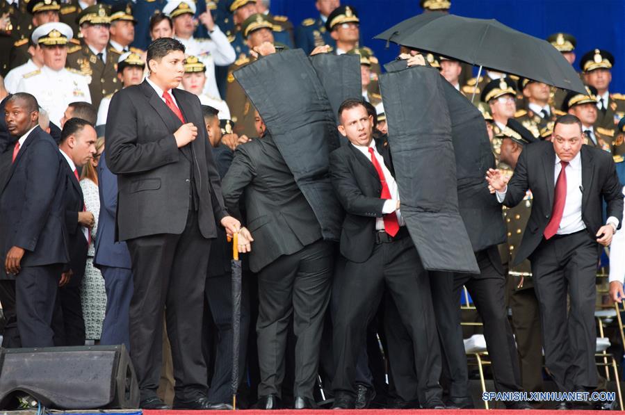 Elementos de seguridad protegen al presidente de Venezuela, Nicolás Maduro, luego que su discurso fuera interrumpido, durante un acto para conmemorar el 81 aniversario de la Guardia Nacional Bolivariana de Venezuela, en la Plaza Bolívar, en Caracas, Venezuela, el 4 de agosto de 2018. Durante una ceremonia conmemorativa del 81 aniversario de la Guardia Nacional Bolivariana de Venezuela en la que ofrecía un discurso el presidente venezolano, Nicolás Maduro, ocurrió el sábado un suceso inesperado que conllevó a la suspensión abrupta de la transmisión y del acto presidencial. Confirman atentado contra presidente Maduro durante acto militar en Caracas. (Xinhua/Str)