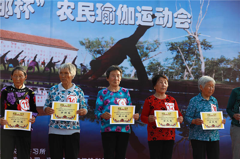 Los ganadores posan con los premios obtenidos durante la práctica de yoga en Yugouliang, aldea situada en Zhangjiakou, provincia de Hebei, 3 de agosto del 2018. [Foto: Zhu Xingxin]