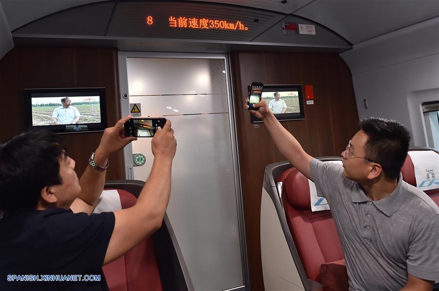 TIANJIN, agosto 8, 2018 (Xinhua) -- Pasajeros toman videos del medidor de velocidad del tren bala Fuxing, que circula en la vía interurbana de Beijing-Tianjin, en China, el 8 de agosto de 2018. China incrementó el miércoles la velocidad máxima que alcanzan los trenes bala en la línea Beijing-Tianjin de 300 a 350 kilómetros por hora (kph), reduciendo el viaje de 35 a 30 minutos. (Xinhua/Yang Baosen)