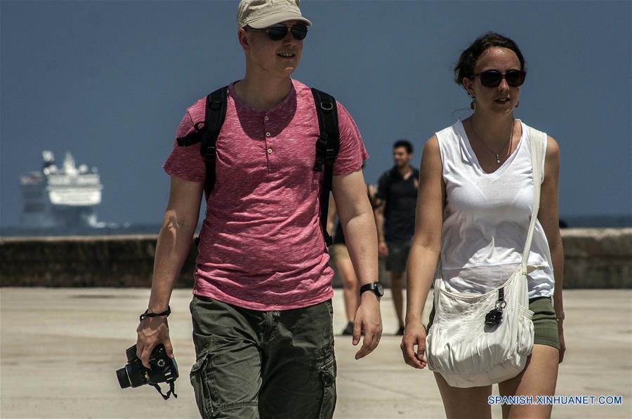 Imagen del 11 de abril de 2018 de turistas extranjeros caminando por el Malecón de La Habana, en La Habana, Cuba. La industria turística cubana, el sector más dinámico de la economía de la isla, se ha desacelerado en lo que va del año como resultado de las medidas restrictivas de la administración del presidente estadounidense Donald Trump. Esta semana, el Ministerio de Turismo de Cuba (MINTUR) informó de la llegada de 3 millones de vacacionistas, una cifra lograda 16 días más tarde que en 2017, la cual confirmó la caída del ritmo de arribos a la isla. Desde 2012, el arribo de vacacionistas extranjeros a Cuba ha mantenido una tasa de crecimiento promedio del 13 por ciento, lo que convirtió a la llamada "Industria del ocio" en una de las principales fuentes de ingresos de la economía cubana. El año pasado, la isla logró la cifra histórica de 4 millones 689.000 visitantes foráneos, cifra que significó un incremento del 16,2 por ciento de turistas respecto al año anterior. (Xinhua/Joaquín Hernández)
