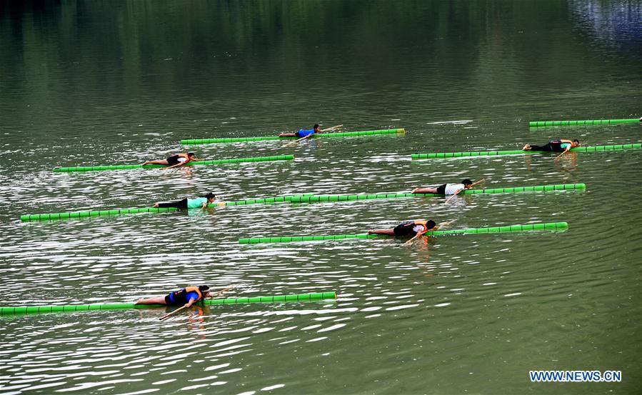 Estudiantes practican sobre una rama de bambú en los canales de Guizhou