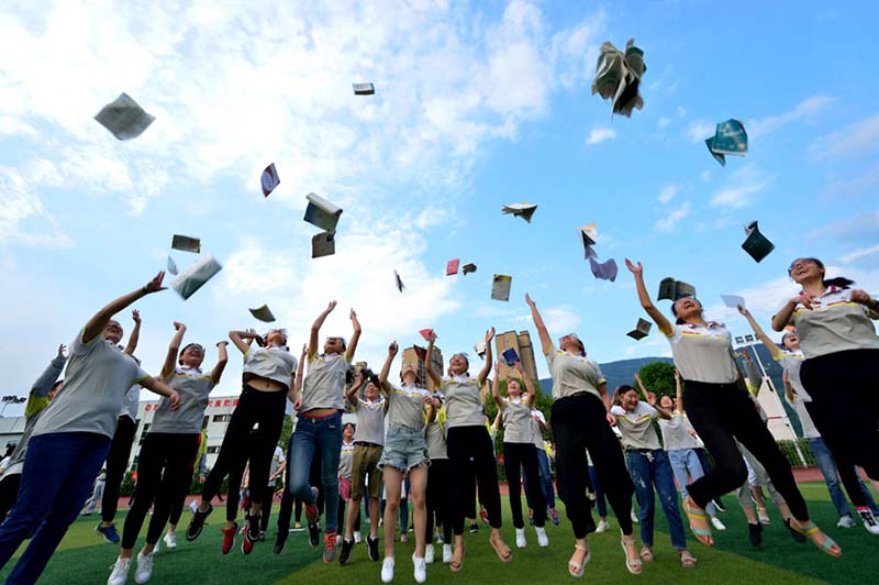 Los estudiantes del condado Baokang, provincia de Hubei, lanzan los libros al aire para celebrar el final del examen de gaokao en junio. [Foto proporcionada a China Daily]