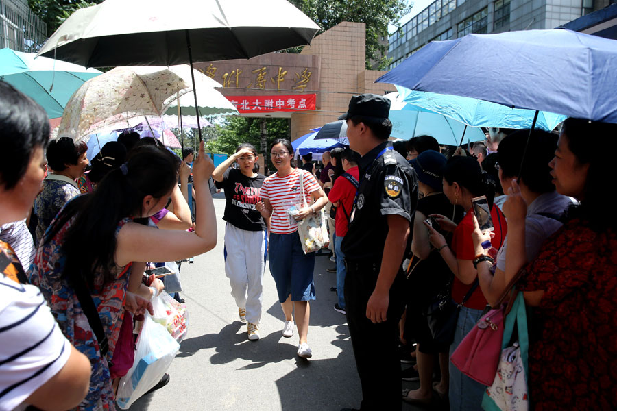 Los padres dan la bienvenida a los niños que han completado el examen en la Escuela afiliada de la Universidad de Pekín en Beijing. [Wang Jing / China Daily]