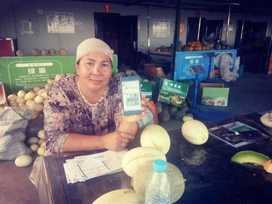 Un agricultor de la aldea de Woymok en la región autónoma uygur de Xinjiang vende melones Hami con su teléfono móvil. [Foto / chinadaily.com.cn]