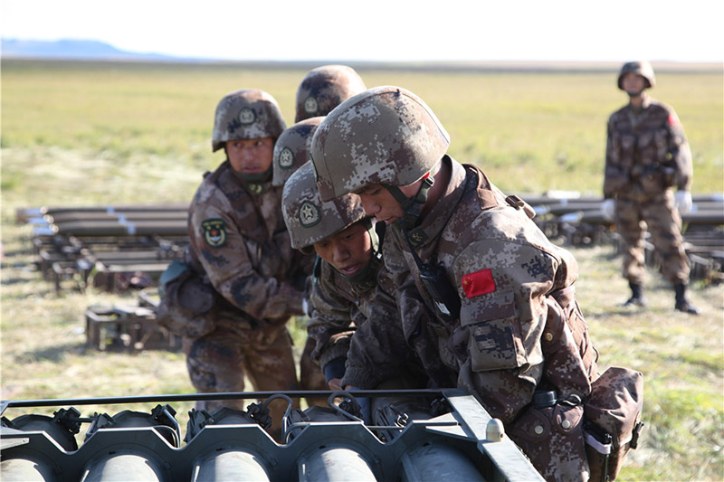 Los soldados chinos cargan cohetes en el lanzador en el campo de entrenamiento de Tsugol en la región rusa Trans-Baikal. [Foto de Pan Mengqi / chinadaily.com.cn]