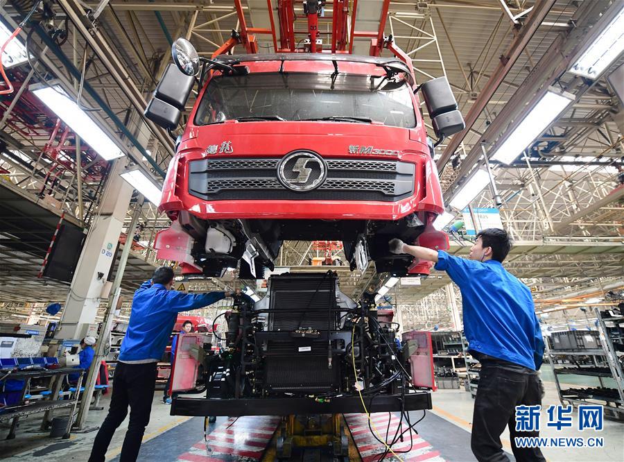 Los trabajadores operan el esparcidor de la cabina en el taller de la fábrica de ensamblaje de automóviles pesados de Shaanxi y conectan la cabina al chasis (foto tomada el 15 de marzo). Agencia de noticias Xinhua, reportero Shao Rui.