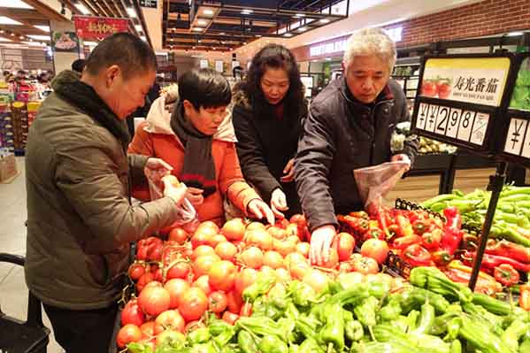 Residentes seleccionan verduras en un supermercado de Fuyang, provincia de Anhui. [Foto: Wang Biao/ China Daily]