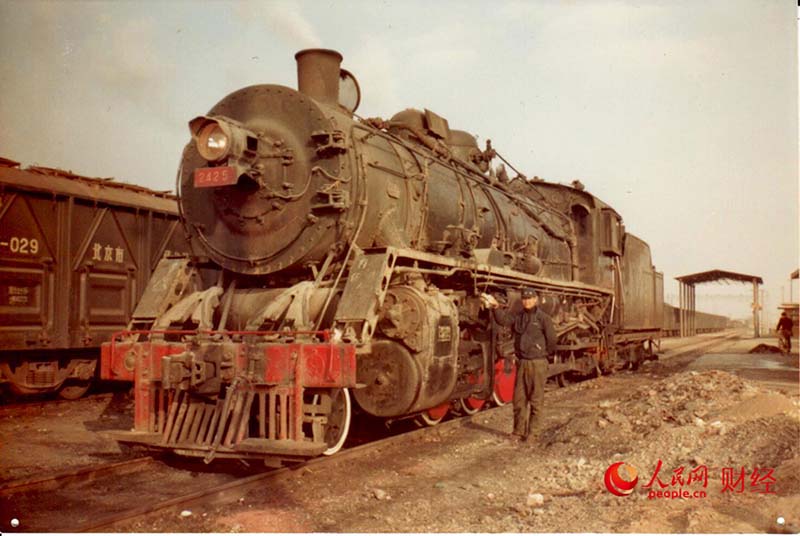 Han Junjia junto a una locomotora de vapor (Foto de archivo)