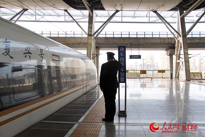 Han Junjia saluda el tren de alta velocidad "Fuxing" desde la plataforma. (Por Yang Lan, Pueblo en Línea)