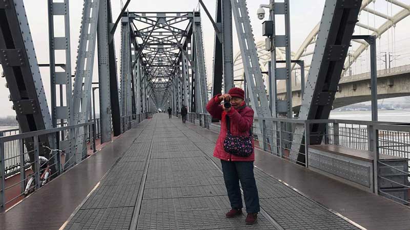 Zhang Ying, de 93 años, toma fotos con su mini cámara digital a la orilla del río Songhua en Harbin, capital de la provincia de Heilongjiang, 14 de diciembre del 2018. [Foto: Wang Kun/ Chinadaily.com.cn]