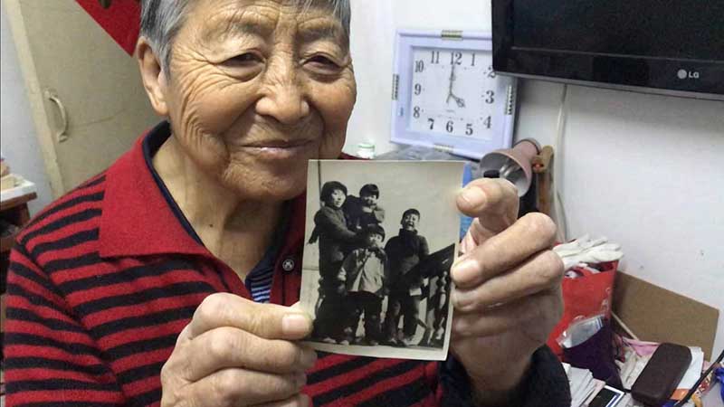 Zhang Ying, de 93 años, sostiene una foto de sus cuatro hijos que tomó en 1959 con su primera cámara. [Foto: Wang Kun/ Chinadaily.com.cn]