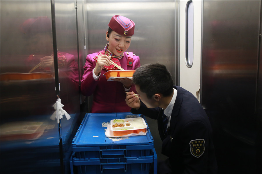 Liu Yuting y un compañero de servicio almuerzan durante una parada del tren. [Foto: proporcionada]