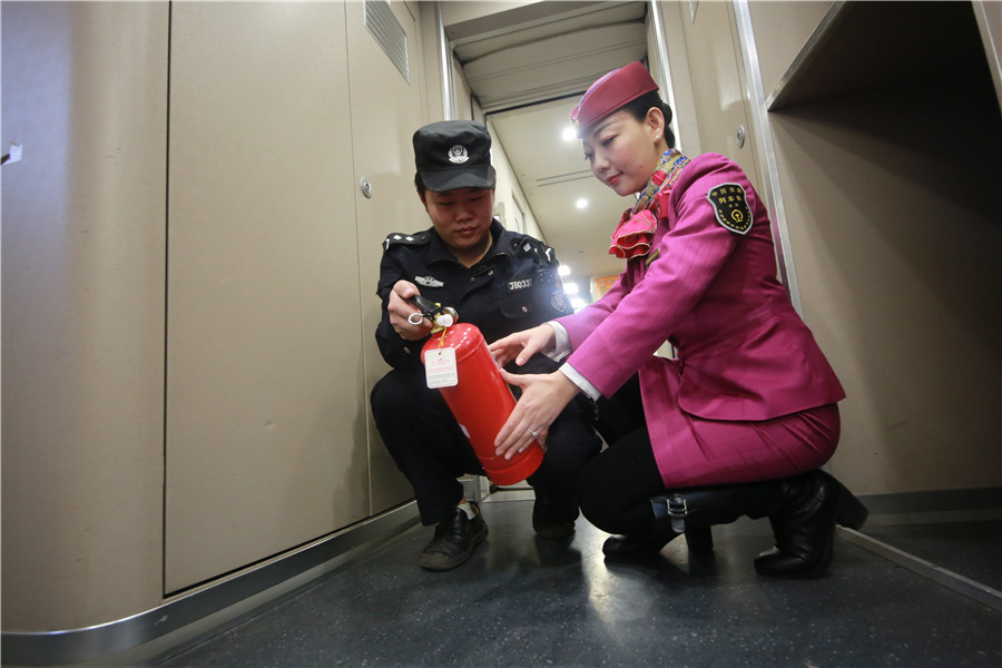 Liu Yuting y un trabajador de seguridad inspeccionan un extintor del tren. [Foto: proporcionada]