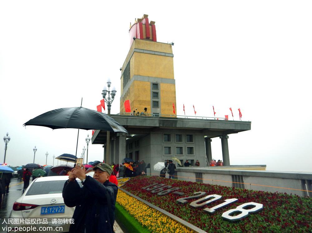 La gente en Nanjing desafía a la lluvia cruzando el recién renovado puente sobre el río Yangtse
