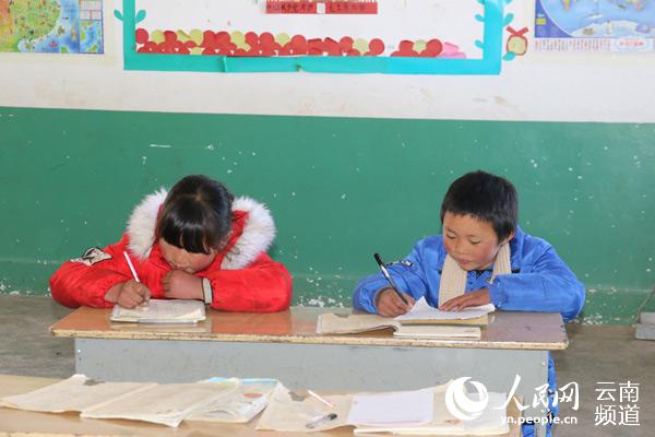 Wang Fuman (a la derecha) hace la tarea en la escuela. (Foto: People Daily/ Xu Qian)