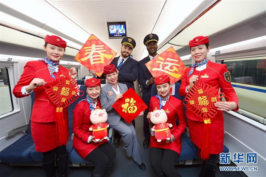 El 20 de enero, en un tren de alta velocidad de la estación ferroviaria Xi'an Norte, el personal del tren y los voluntarios extranjeros se hacen una foto de grupo para dar la bienvenida al Festival de Primavera de 2019.