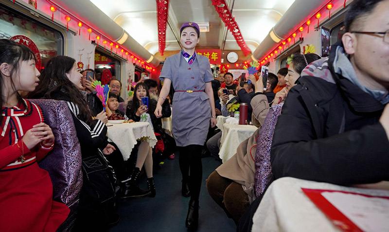 Un asistente de tren modela su uniforme en un tren de Qiqihar, provincia de Heilongjiang, camino a Beijing. Los miembros del personal organizaron una pequeña Gala del Festival de la Primavera para entretener a los pasajeros, muchos de ellos en camino a reunirse con sus familiares, 26 de enero del 2019. [Foto: Cai Yang/ Xinhua]