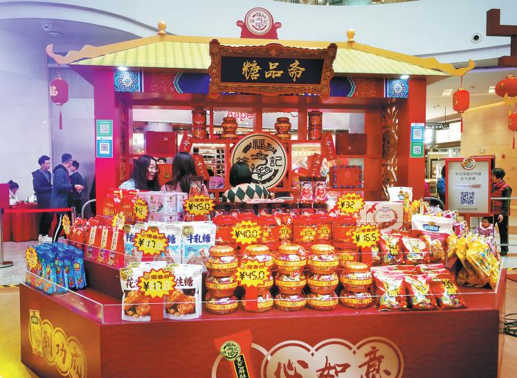 Los consumidores visitan puestos de dulces temáticos del festival en un centro comercial en Guangzhou, provincia de Guangdong. [Foto proporcionada a China Daily]