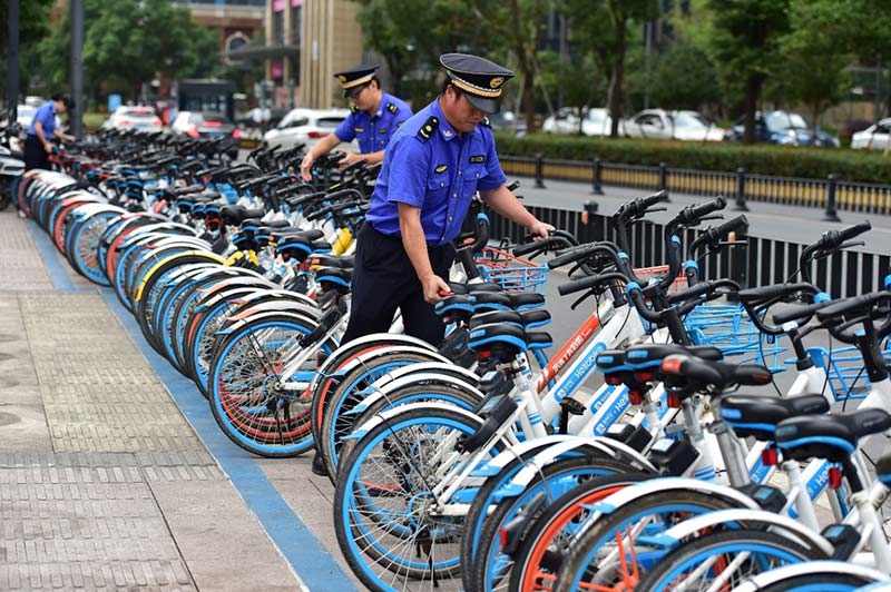 En la tarde del 27 de septiembre de 2018, en Yiwu, provincia de Zhejiang, este de China, el personal de la Oficina de Aplicación de la Ley de Yiwu verificó que las bicicletas compartidas estaban estacionadas correctamente en los espacios previstos para este efecto. (Foto / Diario del Pueblo)