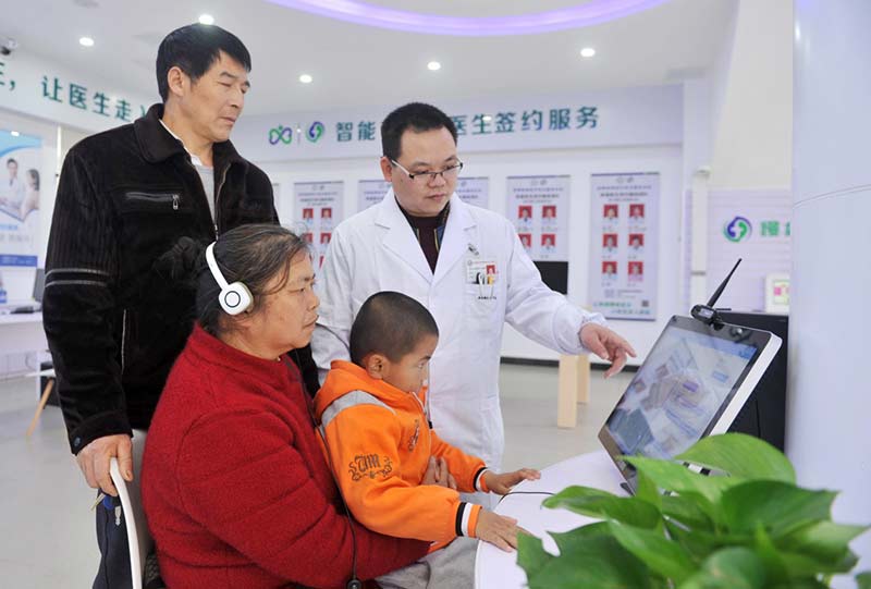 El 4 de marzo de 2019, en el Centro de Servicio Comprensivo Médico Inteligente del condado Dingnan en la provincia de Jiangxi, los miembros del personal instruyen a los ciudadanos a pasar consulta médica a través de la plataforma de consulta remota de internet. (Foto de Chen Dichang / Diario del Pueblo)