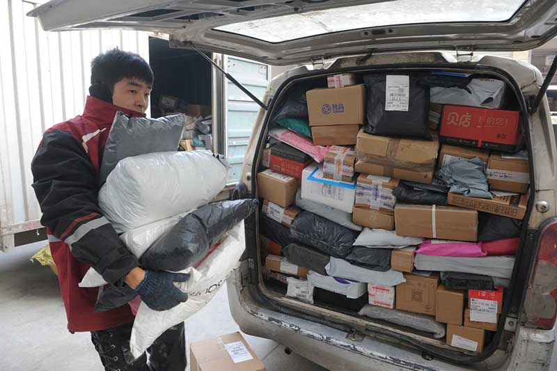 Un trabajador reparte encomiendas en Fuyang, provincia de Anhui, en pleno mes de diciembre. El frenesí de las compras en línea ha generado la expansión del negocio de entrega de paquetes. (Foto: Wang Biao/ China Daily)
