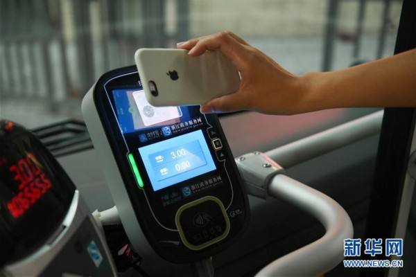 Un pasajero paga el billete por el código QR de Alipay al tomar el autobús, el 20 de julio de 2017. (Foto: Huang Zongzhi / Xinhua)