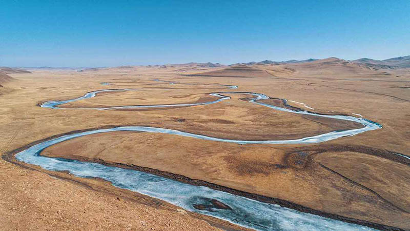 Un río congelado serpentea grácil por la primavera de Mongolia Interior