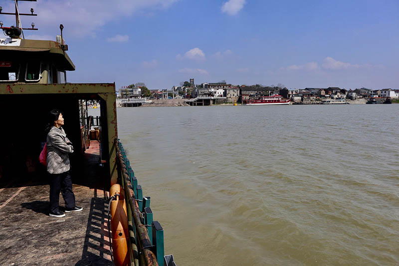 Una mujer viaja en ferry el 25 de marzo de 2019, desde las islas del río Yangtze hasta la orilla oriental del río, donde se encuentra Datong, una antigua ciudad en Tongling, provincia de Anhui. [Foto por Zhu Lixin / chinadaily.com.cn]
