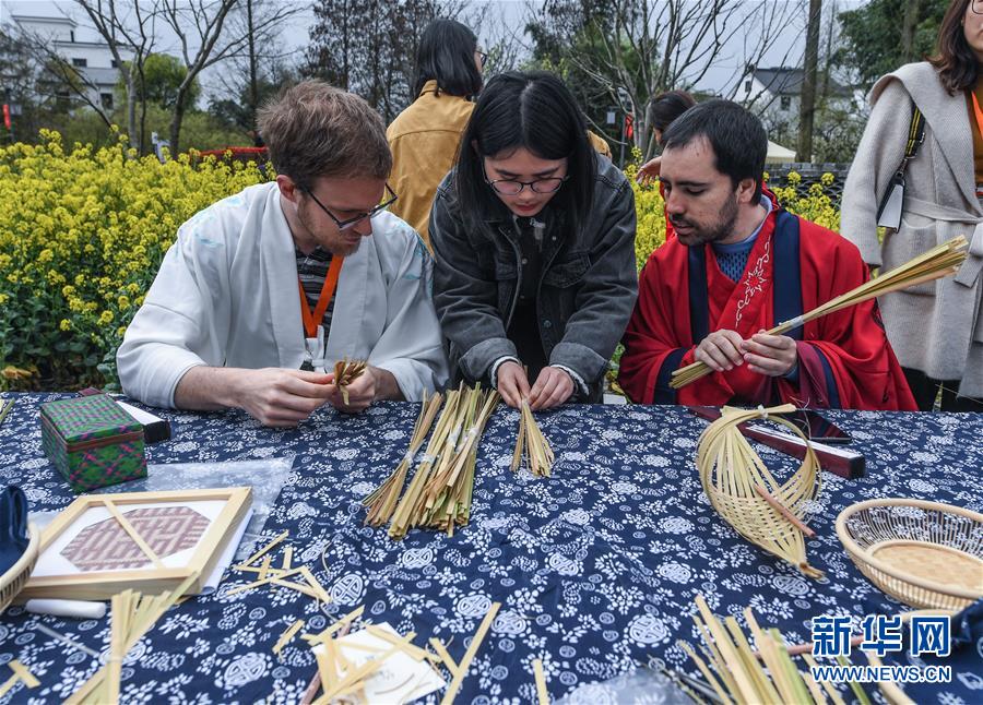 El 31 de marzo, un visitante de Bélgica (izquierda) y otro de España, vestidos con trajes Hanfu, experimentaron la artesanía tradicional local del bambú en Taoyuan.