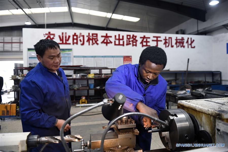 HUNAN, 15 abril, 2019 (Xinhua) -- Imagen del 14 de marzo de 2019, de Mangeh III Fondzenyuy Cedric (d) aprendiendo a usa una máquina, en la Universidad Agrícola de Hunan, en Changsha, provincia de Hunan, en el centro de China. Cedric, de 25 años, es de Camerún. Habiendo siendo testigo de la avanzada ciencia agrícola y tecnología y equipo de las empresas chinas, llegó a China en 2017 y estudió un posgrado con especialización en ingeniería de mecanización agrícola en la Escuela de Ingeniería de la Universidad de Hunan después de completar sus estudios de licenciatura. Cedric estudia principalmente mecanización y automatización agrícola, biología moderna, operación y gestión agrícola moderna, extensión de tecnología y ciencia agrícola y otros cursos profesionales en la universidad. Después de estudiar en China durante dos años, Cedric no sólo habla chino con fluidez, sino que también aprendió a operar más de 20 tipos de recursos agrícolas, dominó los métodos de manejo de información agrícola y se está convirtiendo en un talento agrícola moderno interdisciplinario. Cedric dijo que después de regresar a Camerún, aplicará lo que aprendió en China a la producción agrícola de su ciudad natal. Como Cedric, cada vez más estudiantes africanos van a Hunan a estudiar en los últimos años, especializándose en agronomía, medicina, administración de empresas, ingeniería civil, etc. Mientras aprendían conocimientos profesionales, sintieron el encanto de la cultura china y profundizaron la amistad con profesores y estudiantes de China. (Xinhua/Li Ga)