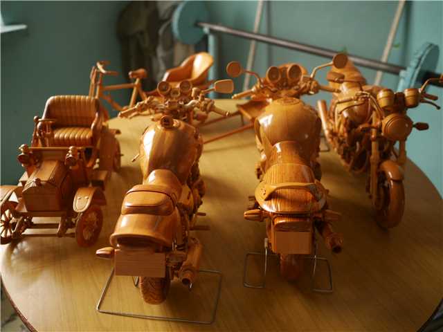 Chuai Mige muestra una motocicleta de madera tallada que él creó. [Foto por Ding Luyang / chinadaily.com.cn]