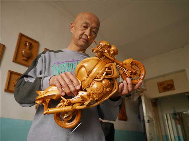 Parte de una motocicleta de madera tallada por Chuai Mige. [Foto por Ding Luyang / chinadaily.com.cn]