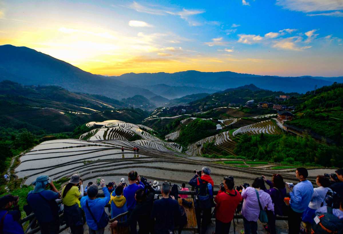 Miles de turistas disfrutan amanecer en las famosas terrazas de Longji, en Longsheng, Región Autónoma Guangxi Zhuang, 3 de junio del 2019. [Foto: Pan Zhixiang/chinadaily.com.cn]