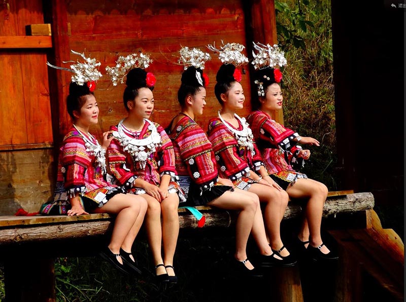 Mujeres de la etnia Miao de la aldea Xinqiao en Leishan, provincia de Guizhou, modelan su distintivo vestido tradicional, que incluye minifalda. [Fotografía: Yu Guode/ Chinadaily.com.cn]