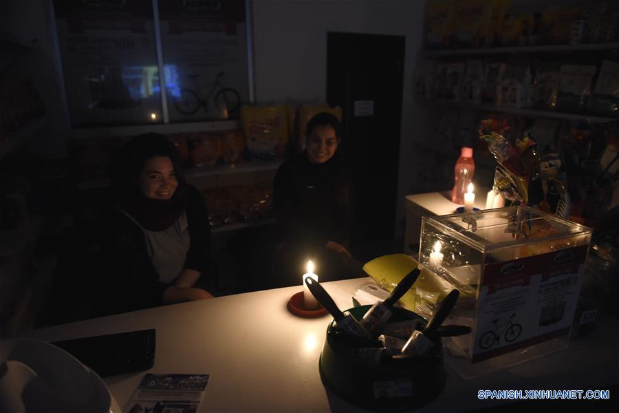 MONTEVIDEO, 16 junio, 2019 (Xinhua) -- Mujeres atienden una veterinaria con luces de velas durante un corte masivo de energía, en Montevideo, capital de Uruguay, el 16 de junio de 2019. La empresa concesionaria del servicio Edesur, que abastece de energía, indicó que "una falla masiva en el sistema de interconexión eléctrica dejó sin energía a Uruguay y Argentina". (Xinhua/Nicolás Celaya)