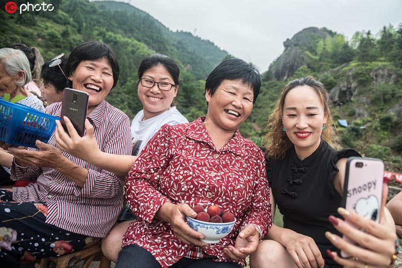 Con la ayuda de los jóvenes, a través de plataformas en línea que transmiten en directo, los ancianos de la aldea Sidu venden su cosecha de bayas chinas (yangmei), 12 de junio del 2019. [Foto: IC]