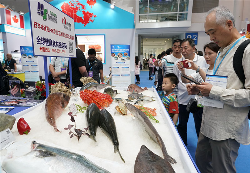 Los visitantes observan el marisco en el stand de una empresa japonesa durante una exposición de productos del mar en Fuzhou, capital de la provincia de Fujian. [Foto / Xinhua]