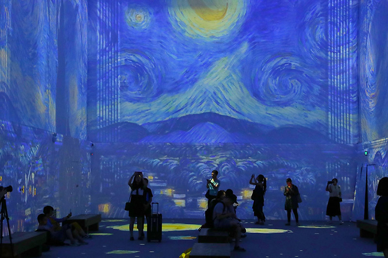 Los visitantes toman fotos de las pinturas de Van Gogh proyectadas en las pantallas la exposición “Experiencia inmersiva con Van Gogh”, abierta al público en el Museo Nacional de China. [Foto: Jiang Dong/ China Daily]
