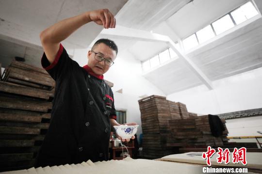 Jiang Guangming polvorea el tofu con sal para hacerlo más fresco.[foto: Fan Chengzhu de Chinanews.com]