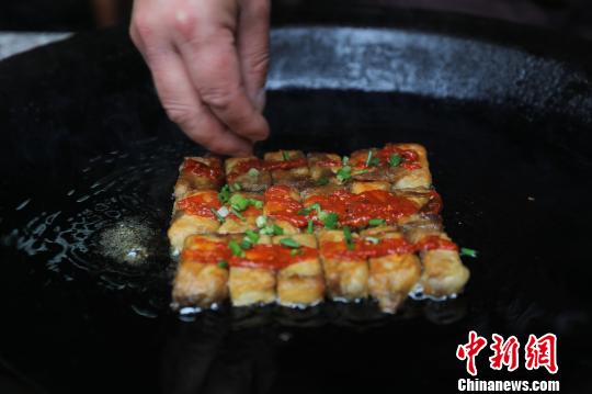 Tofu frito de tono dorado.[Foto: Fan Chengzhu/ Chinanews.com]