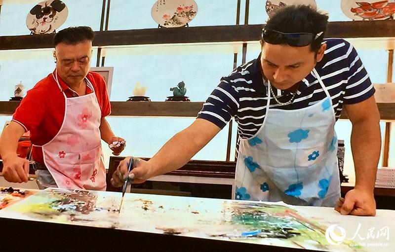 El artista chino Wu Xiaolin y el cubano Li Domínguez Fong durante la preparación de la obra del sobre postal artístico sino-cubano conmemorativo por el 70º aniversario de la fundación de la República Popular China, Beijing, 6 de julio del 2019. (Foto: YAC)
