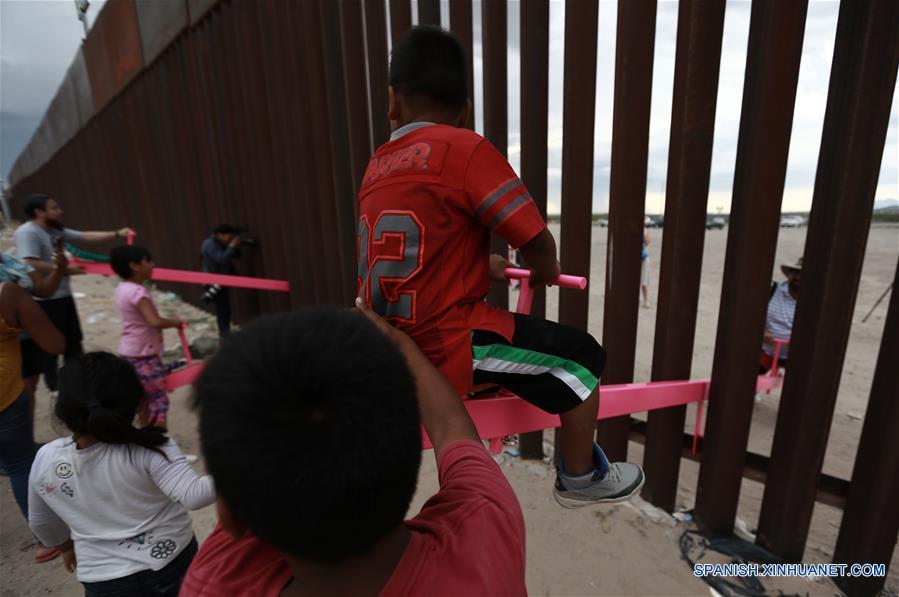 Personas juegan en sube y baja entre muro de acero en Ciudad Juárez