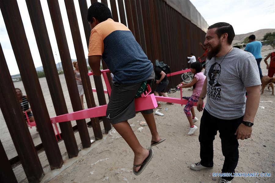 Personas juegan en sube y baja entre muro de acero en Ciudad Juárez