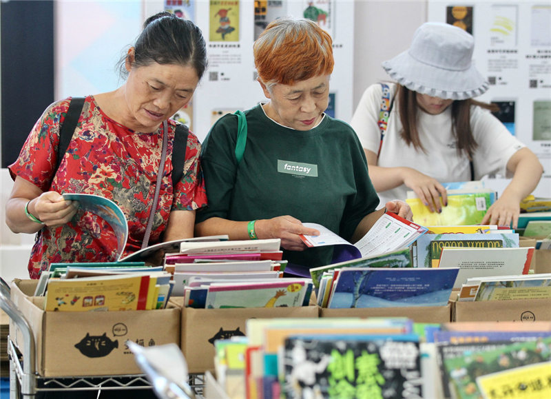 Visitantes leen libros en la XVI Exposición Internacional del Libro de Beijing, 21 de agosto del 2019. [Foto: Zhang Wei/ Chinadaily.com.cn]