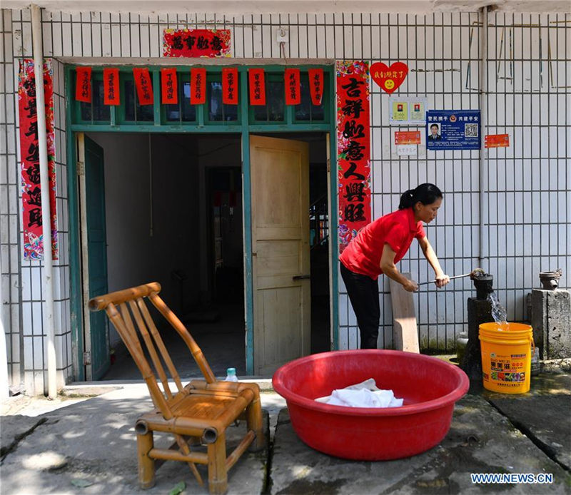 En su casa, Liu Lihong busca agua para lavar la ropa. Dabaidi, Ruijin, provincia de Jiangxi, 19 de agosto del 2019.(Foto: Xinhua / Hu Chenhuan)