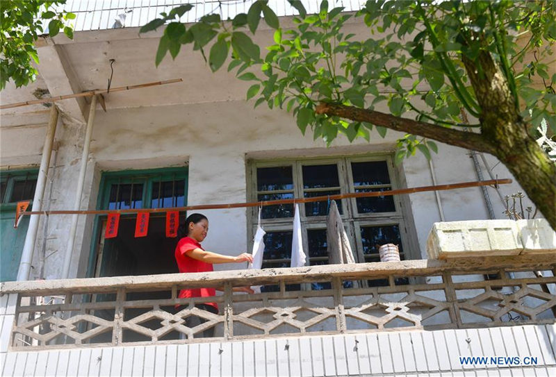 Liu Lihong seca la ropa en su casa. Dabaidi, Ruijin, provincia de Jiangxi, 19 de agosto del 2019.(Foto: Xinhua / Hu Chenhuan)