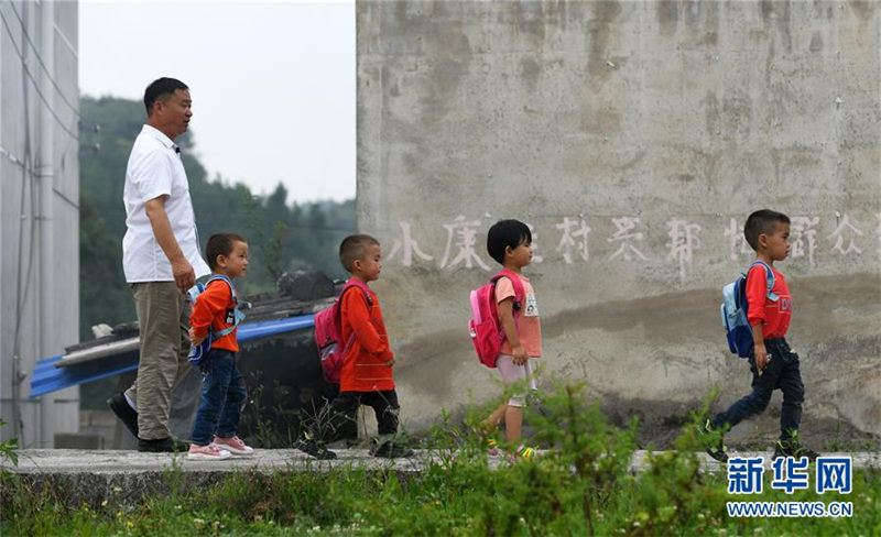 Wu Guoxian acompaña a sus alumnos mientras caminan a casa después de la escuela, el 26 de agosto de 2019. [Foto / Xinhua]