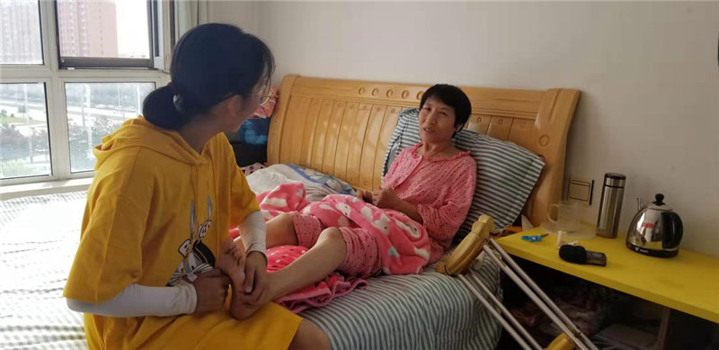 Liu Ximeng da un masaje a su madre en su casa en Harbin, capital de la provincia de Heilongjiang, noreste de China, el 5 de septiembre. [Foto proporcionada a chinadaily.com.cn]