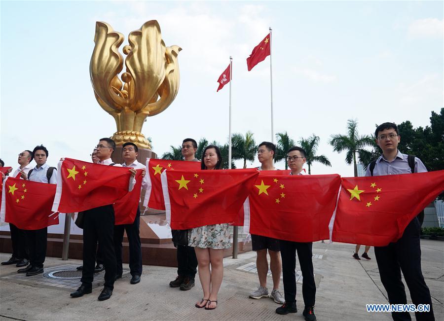 Los jóvenes sostienen la bandera nacional de China durante la flash mob en Hong Kong