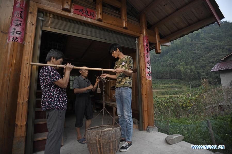 Zhang Hui compra manís a un agricultor en la ciudad de Dongping del condado de Anhua, provincia de Hunan, en el centro de China, el 22 de agosto de 2019.
